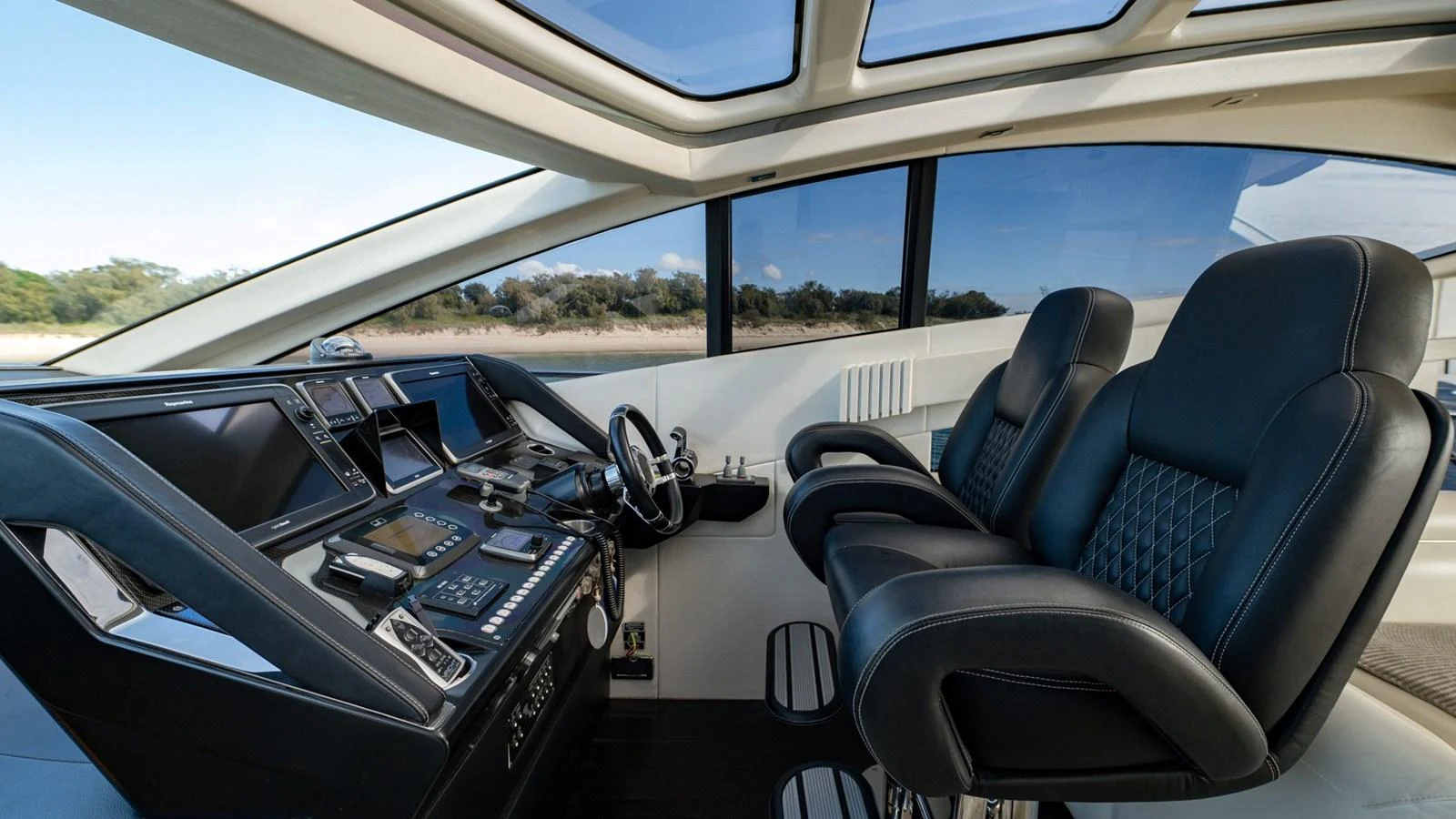 The helm station features luxurious seating and state-of-the-art navigation equipment under a panoramic glass roof. aboard ZAZA Yacht for Sale