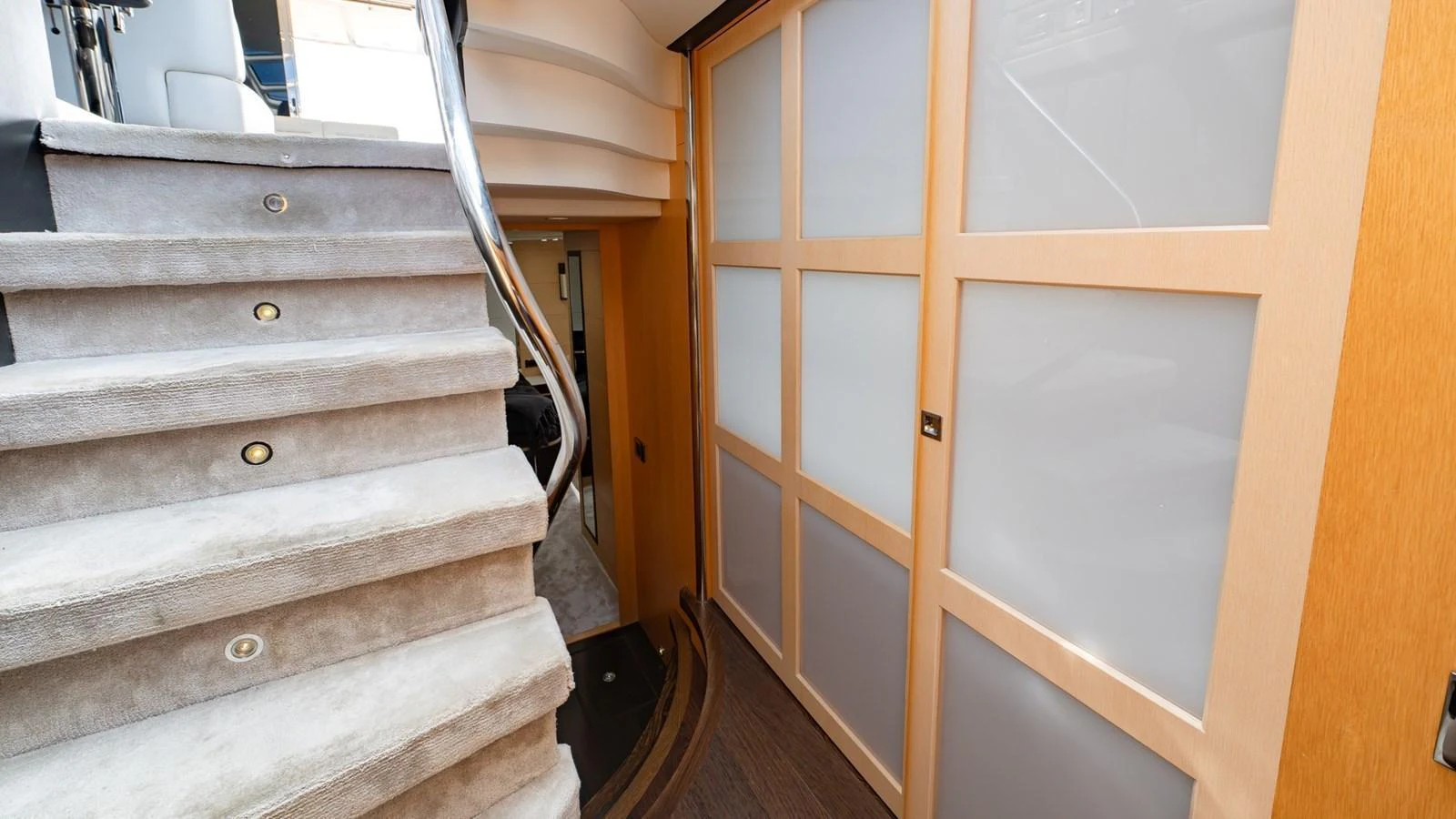 The image showcases a modern interior hallway with carpeted stairs and sliding doors. aboard ZAZA Yacht for Sale