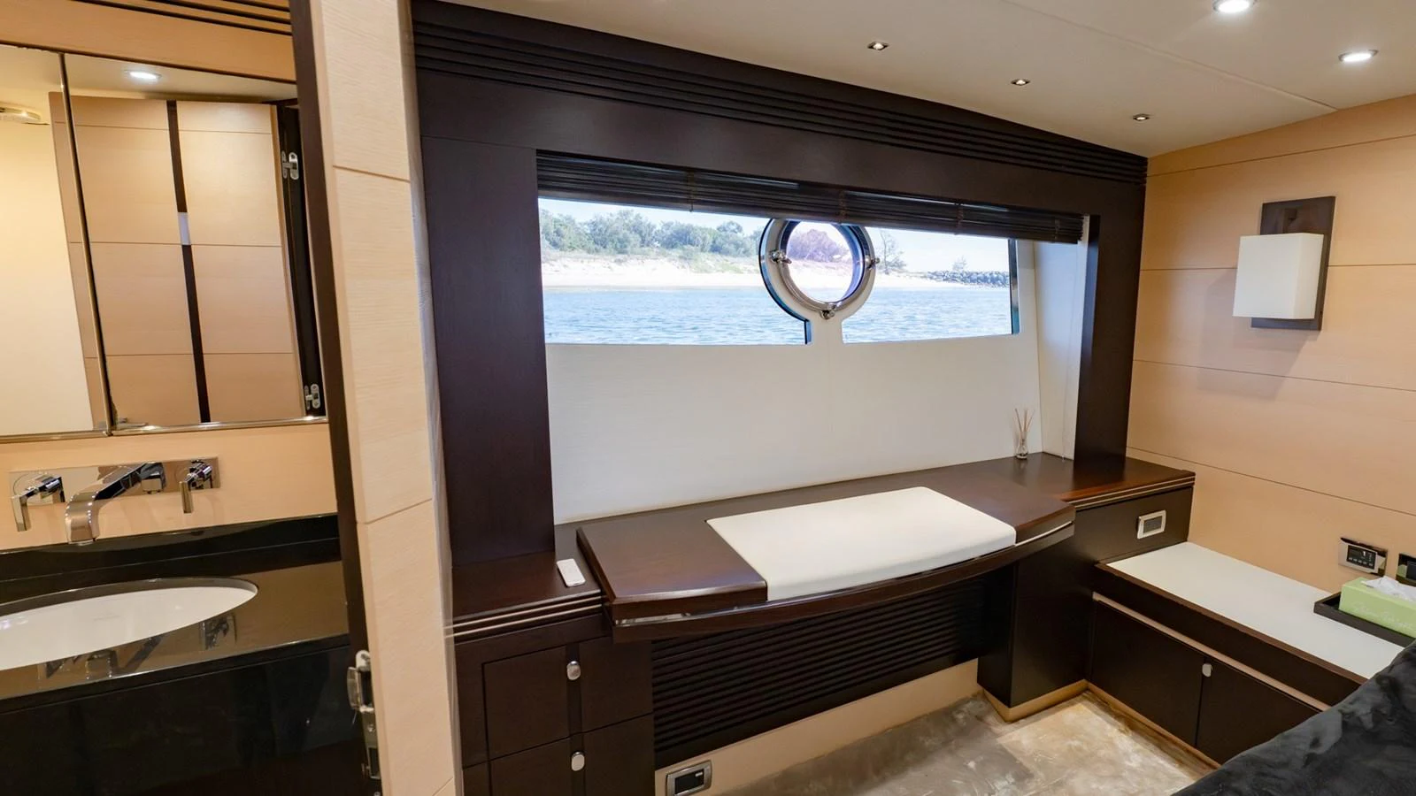 The yacht's interior features a sleek and modern design with a porthole window offering a view of the water. aboard ZAZA Yacht for Sale
