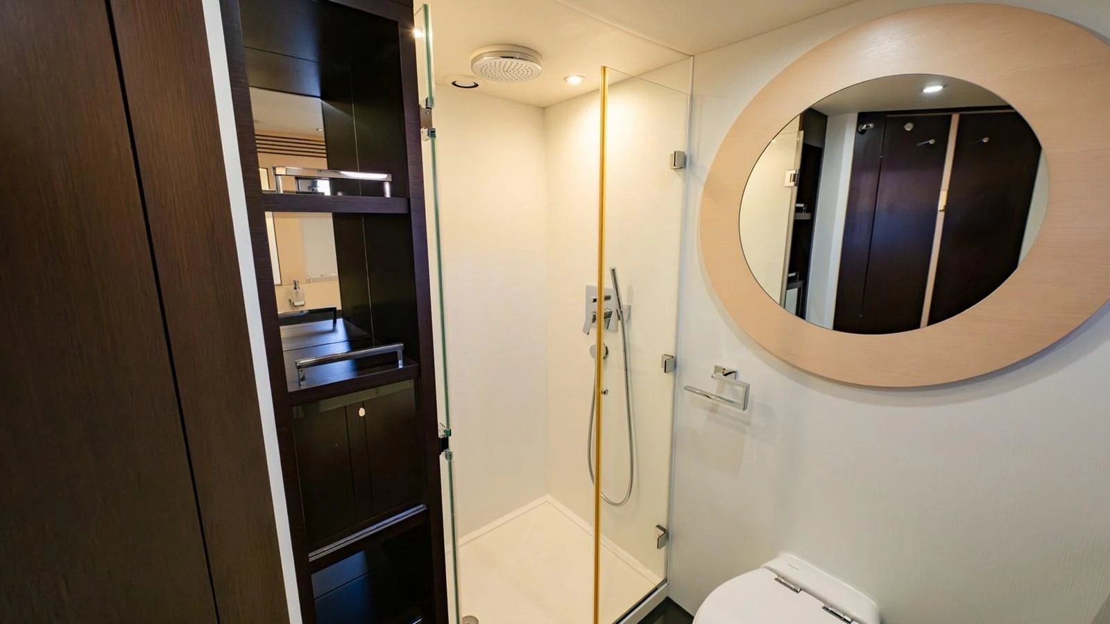 The yacht's bathroom features a modern shower, sleek cabinetry, and a stylish oval mirror. aboard ZAZA Yacht for Sale
