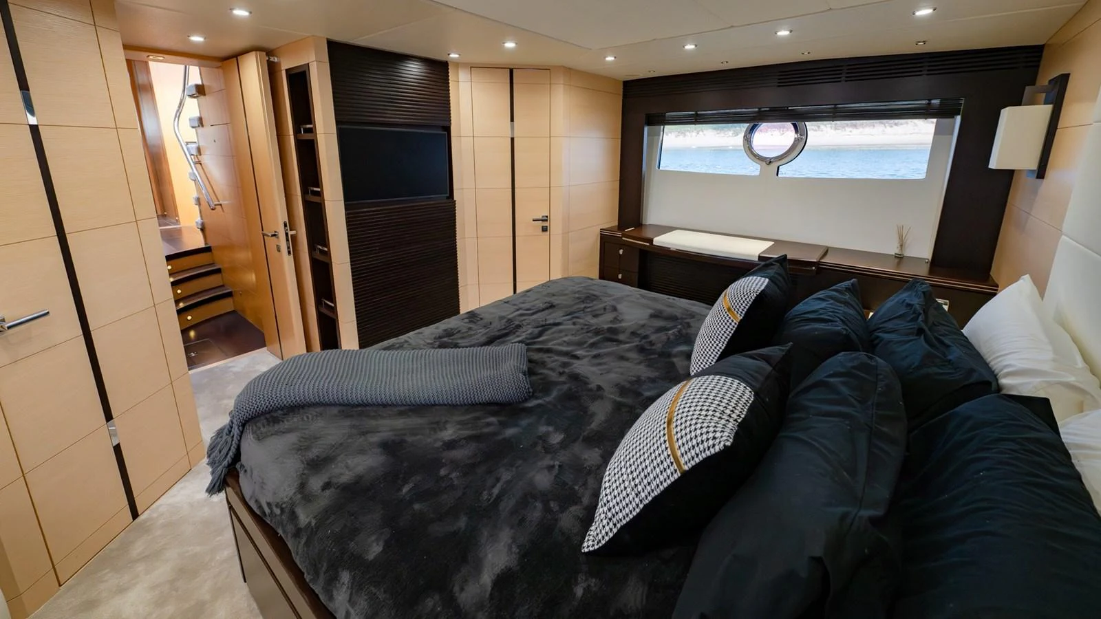 The master stateroom features a luxurious bed with plush bedding and ample natural light from a large window. aboard ZAZA Yacht for Sale