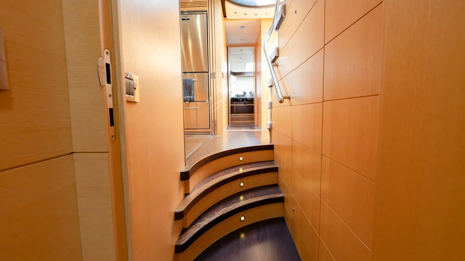 A warm, inviting hallway with wooden paneling and steps leading to the galley. aboard ZAZA Yacht for Sale