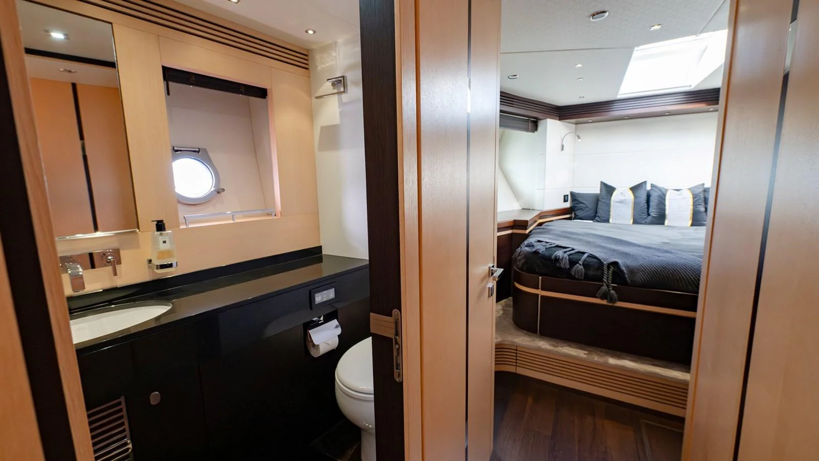 The image showcases a luxurious stateroom with an en-suite bathroom, featuring modern design and ample natural light. aboard ZAZA Yacht for Sale