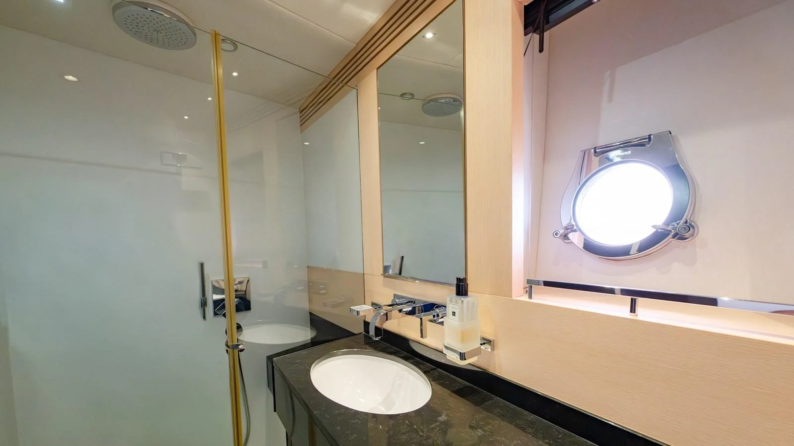 The yacht's bathroom features a sleek design with modern fixtures and a porthole window. aboard ZAZA Yacht for Sale