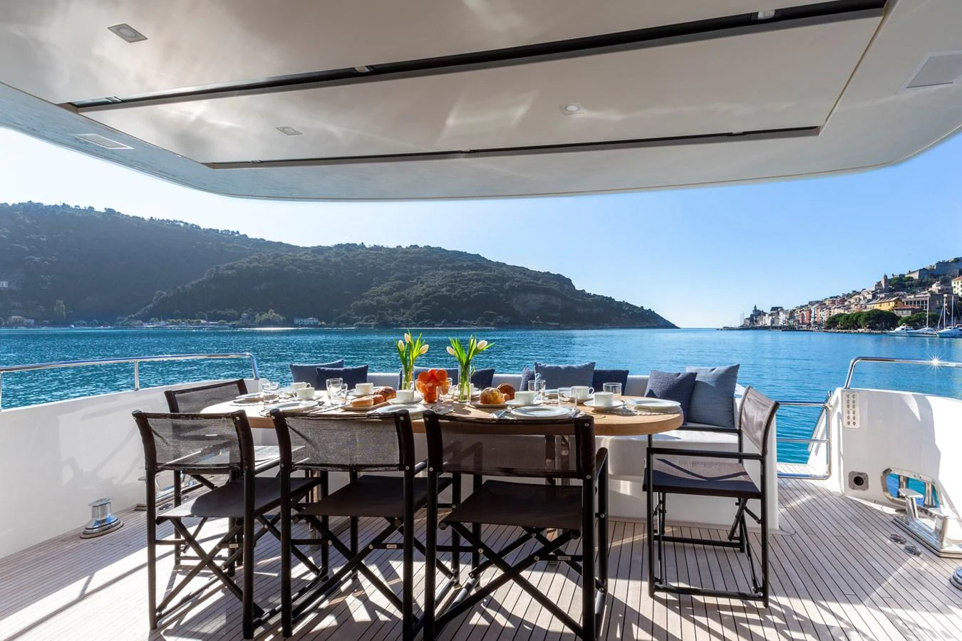 The aft deck features a stylish dining area with a stunning view of the water and surrounding landscape. aboard QUEEN MARTINA Yacht for Sale