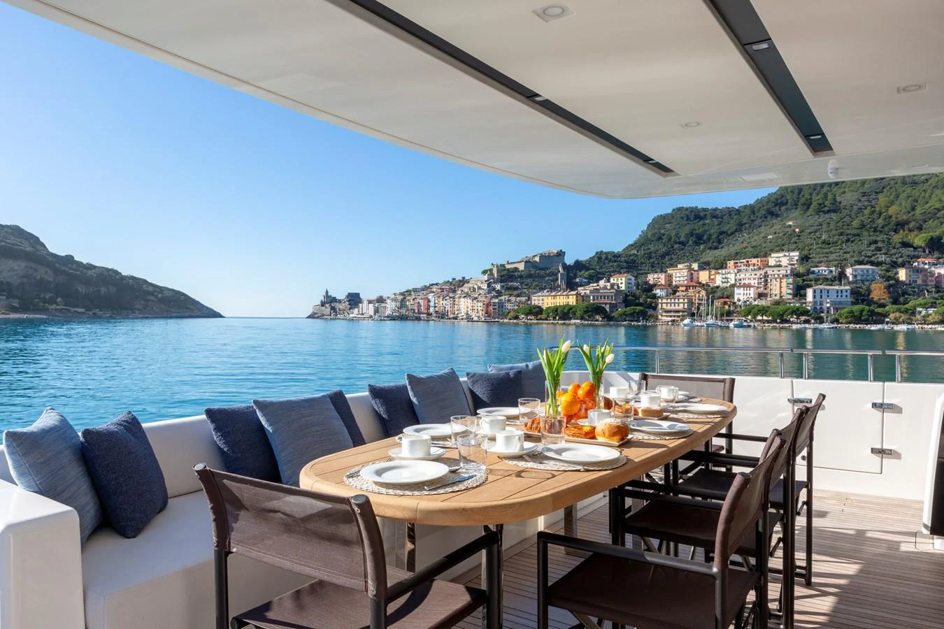 The aft deck features an elegant dining area with a stunning view of the coastline. aboard QUEEN MARTINA Yacht for Sale