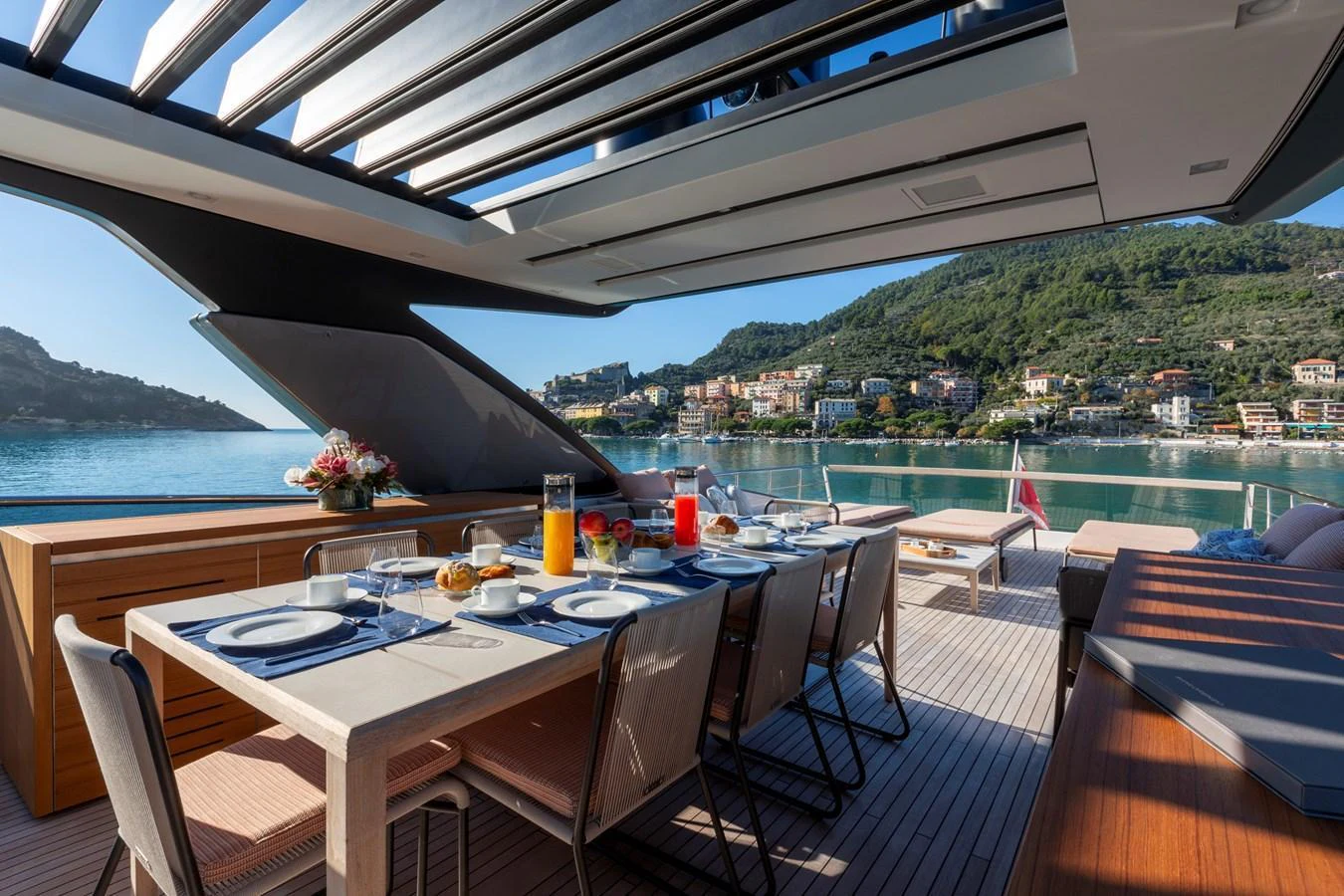 The yacht features a stunning alfresco dining area with a scenic view of the coastline. aboard QUEEN MARTINA Yacht for Sale