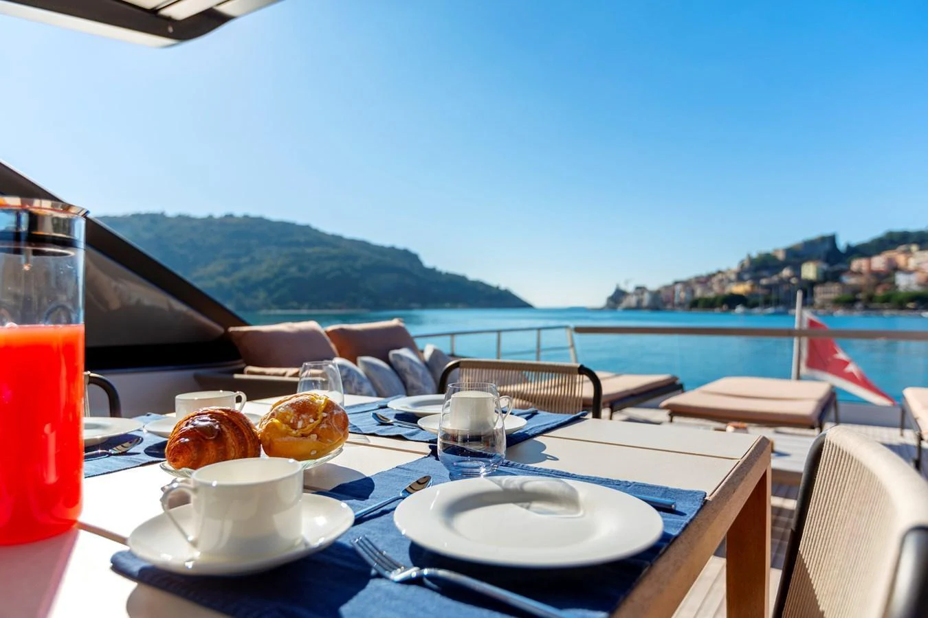 An inviting alfresco dining area set with breakfast items, offering stunning views of the surrounding waters and landscape. aboard QUEEN MARTINA Yacht for Sale
