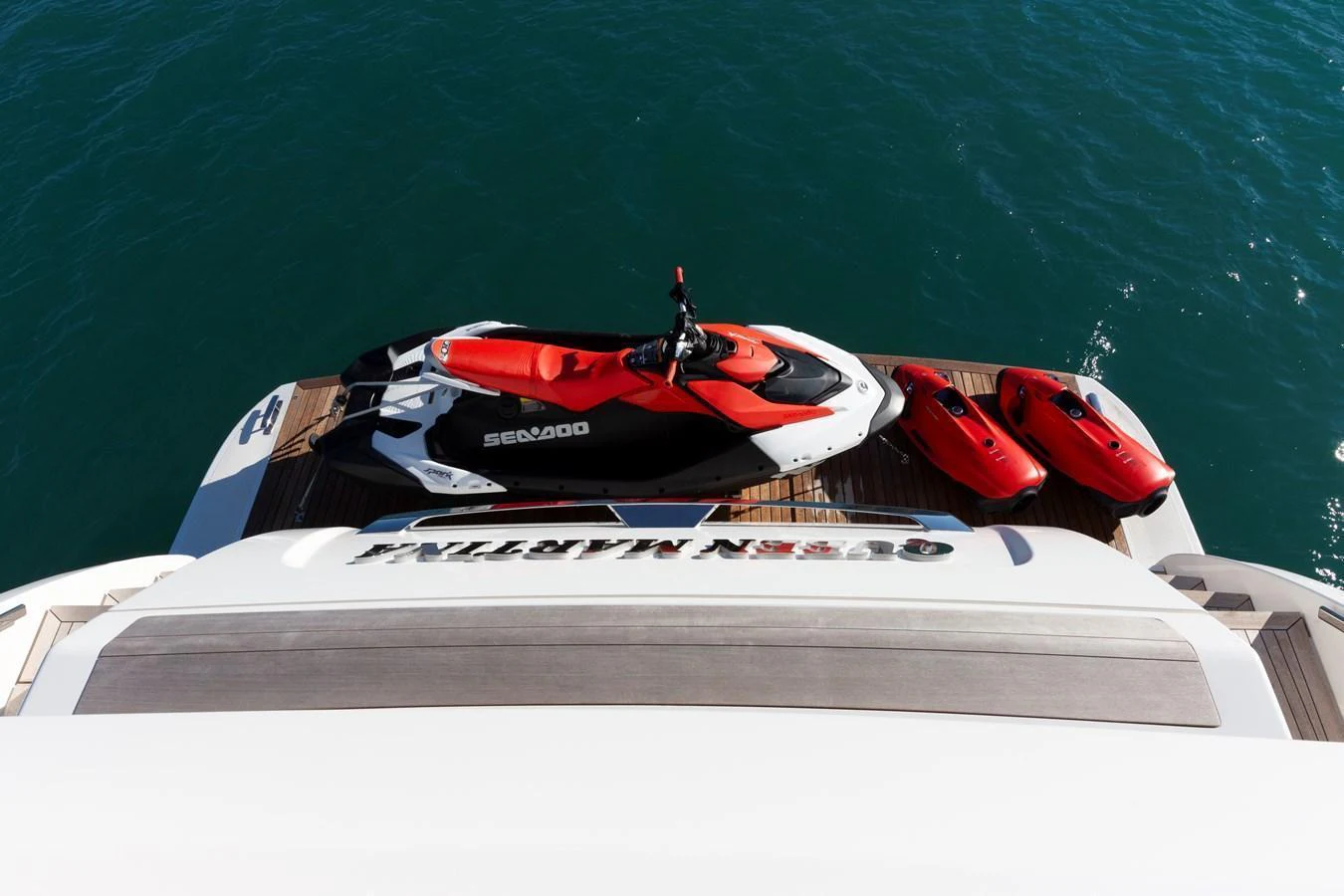 The yacht's swim platform features a Sea-Doo jet ski and two smaller watercraft, ready for aquatic adventures. aboard QUEEN MARTINA Yacht for Sale