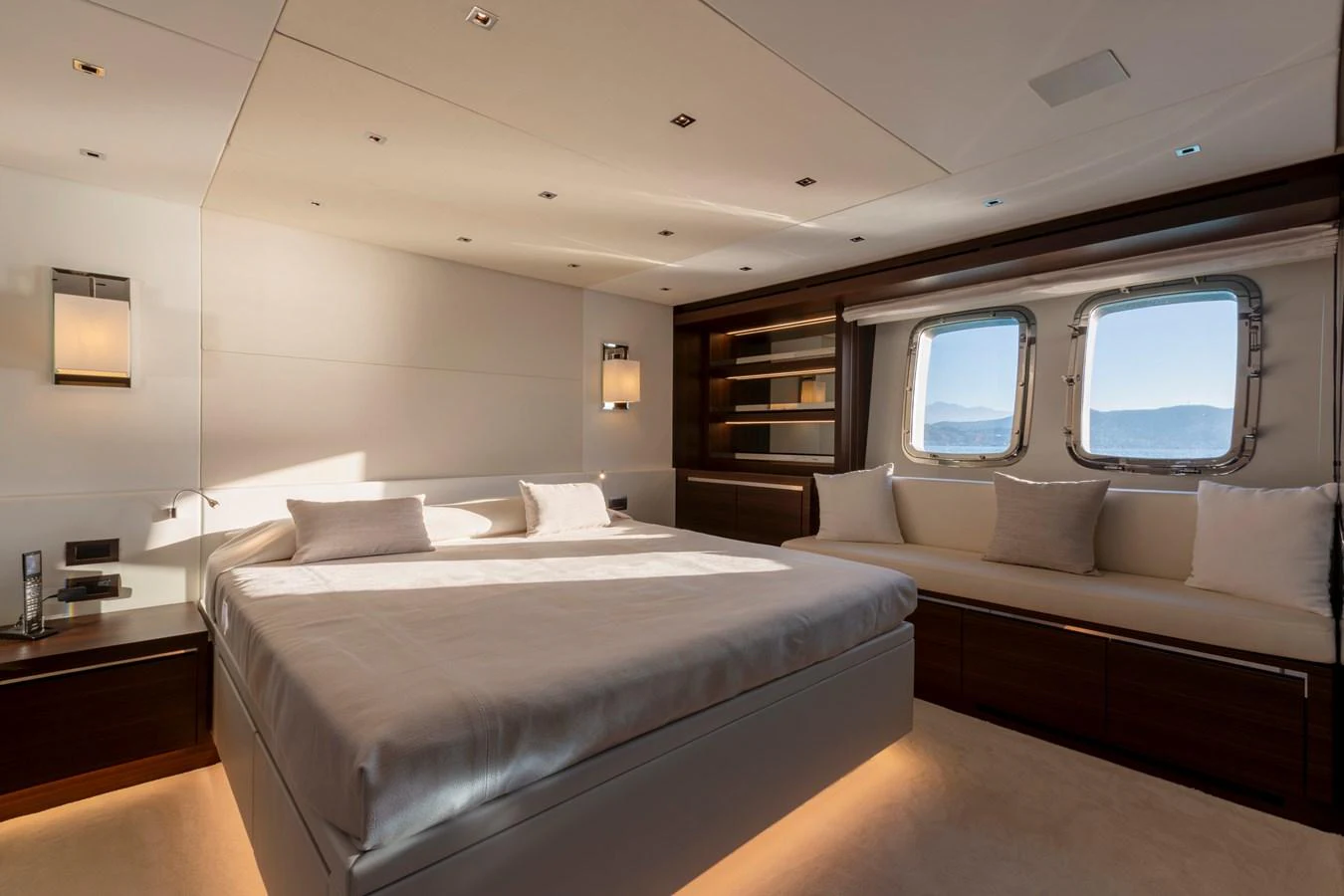The master stateroom features a spacious bed, elegant lighting, and large windows with a serene view. aboard QUEEN MARTINA Yacht for Sale