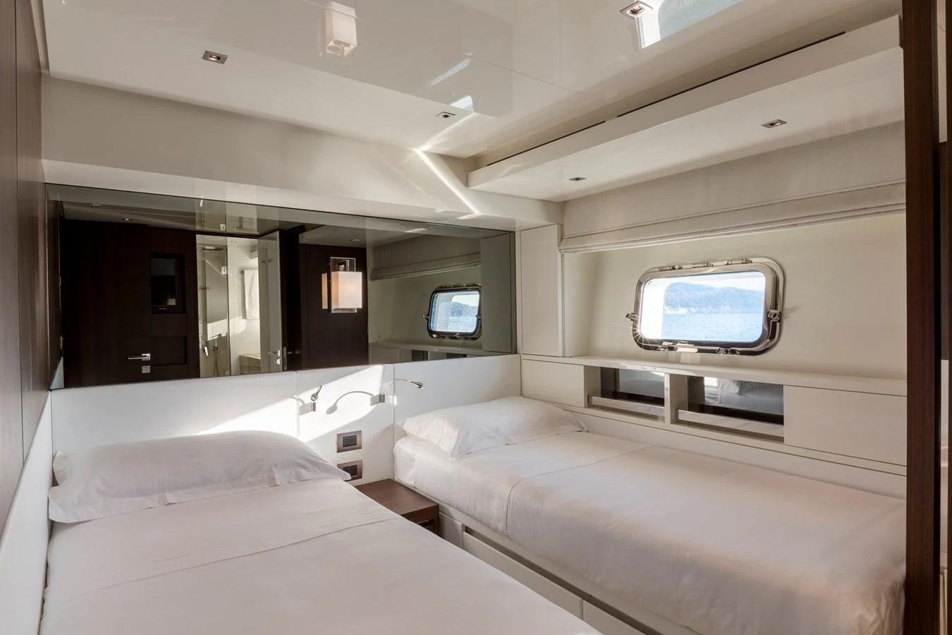 The guest stateroom features twin beds and a large window offering a serene view of the water. aboard QUEEN MARTINA Yacht for Sale