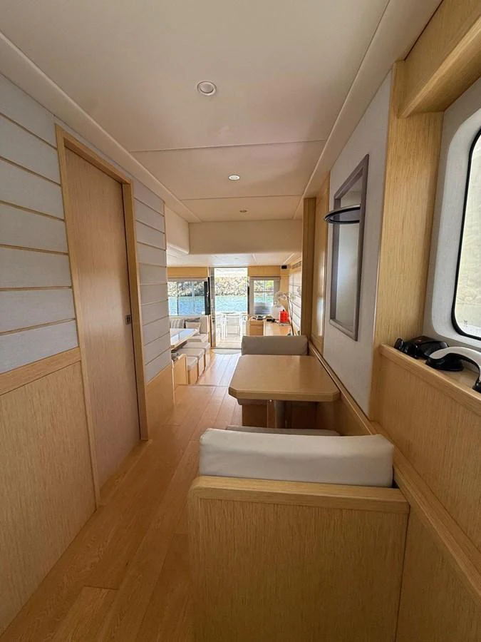 a room with a wood floor and a wood floor and a large window aboard NEVER TOO LATE Yacht for Sale