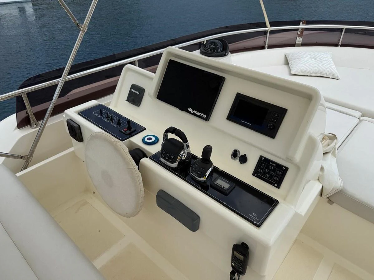 a white boat with black and silver buttons and a black device on it aboard NEVER TOO LATE Yacht for Sale