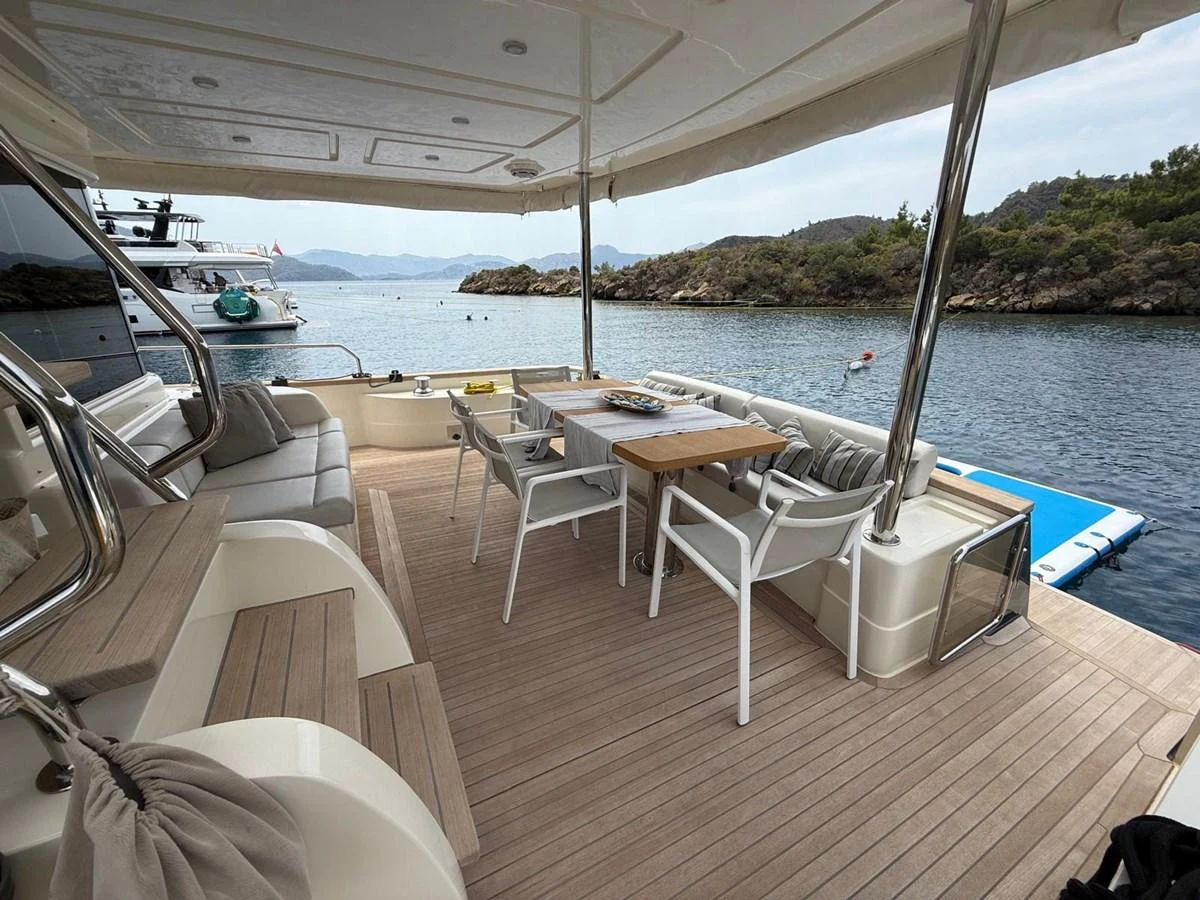 a deck with chairs and tables on it aboard NEVER TOO LATE Yacht for Sale