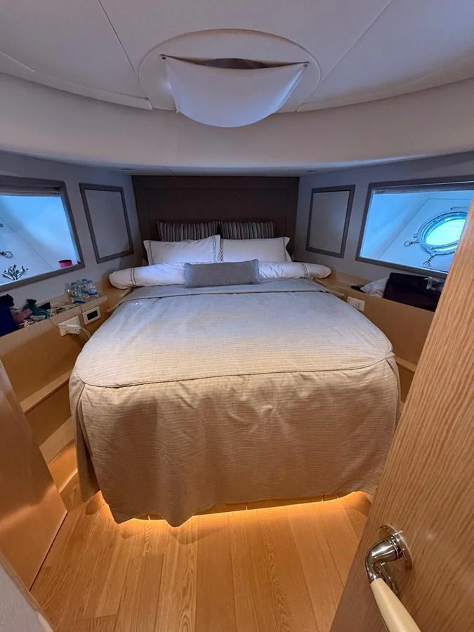a bed with a white comforter aboard NEVER TOO LATE Yacht for Sale