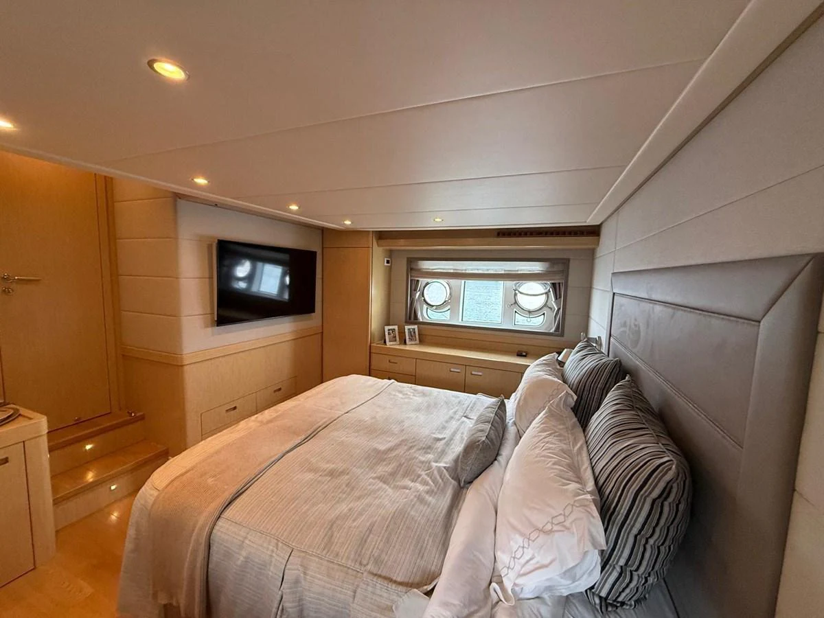 a bedroom with a bed and a television aboard NEVER TOO LATE Yacht for Sale