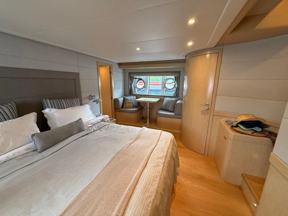 a bedroom with a bed and a tv on the wall aboard NEVER TOO LATE Yacht for Sale