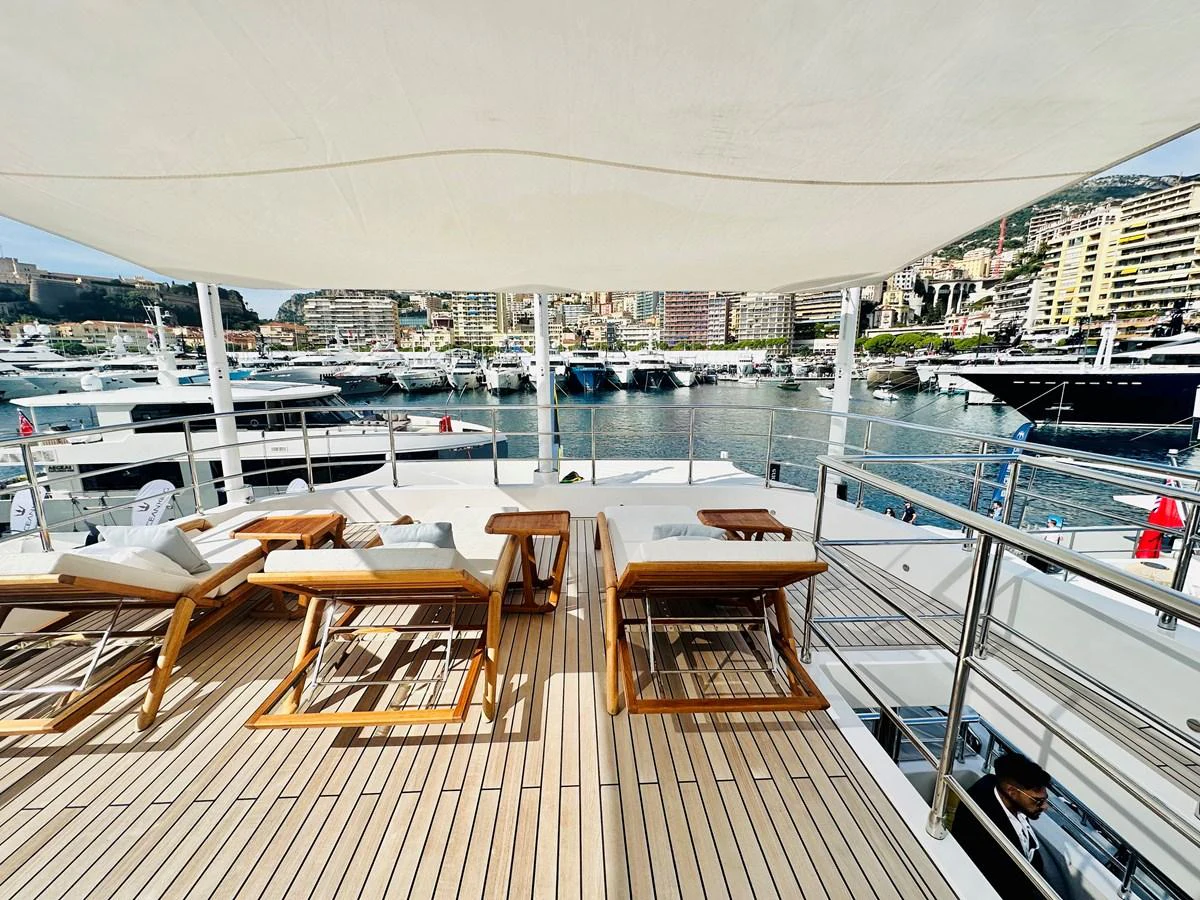 a deck with a view of a city and boats in the water aboard OPTIMISM Yacht for Sale