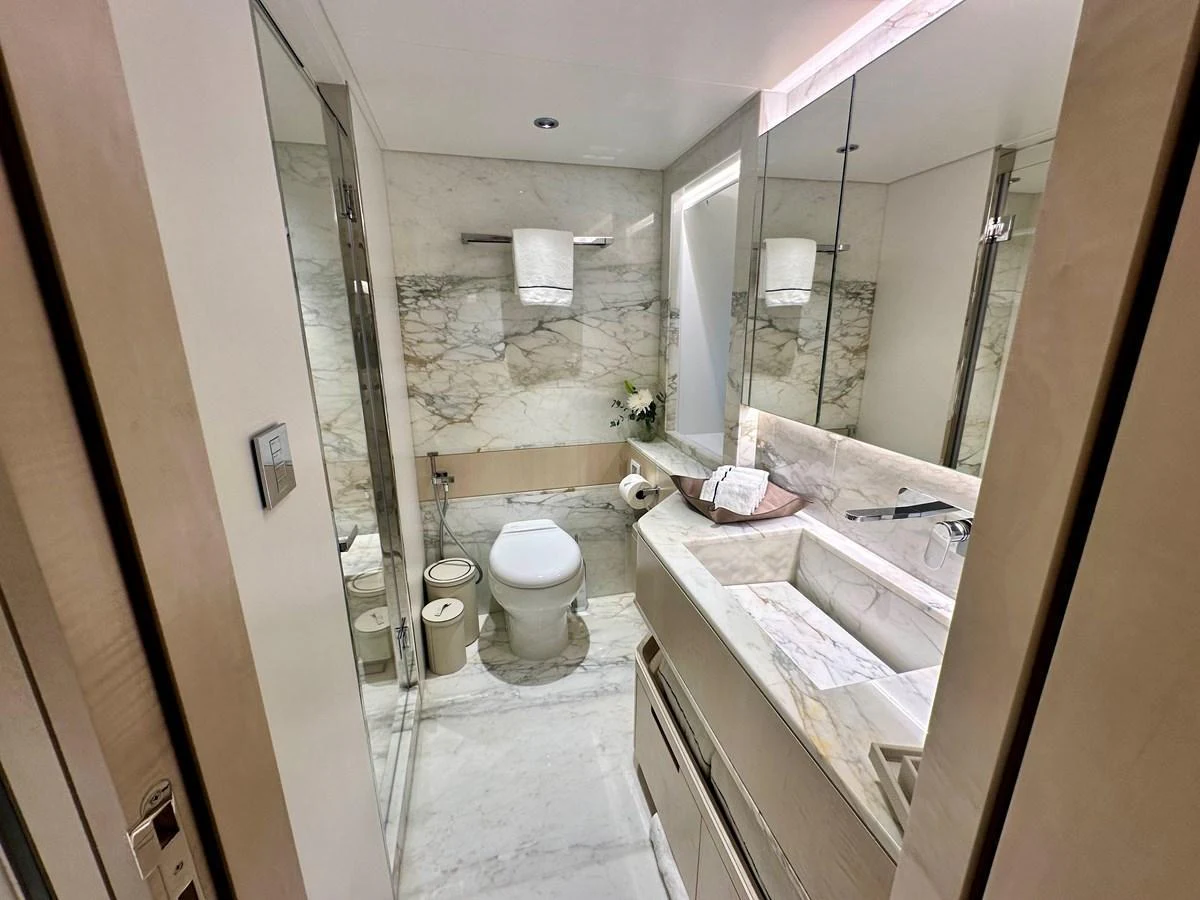The yacht's bathroom features elegant marble surfaces and modern fixtures. aboard OPTIMISM Yacht for Sale