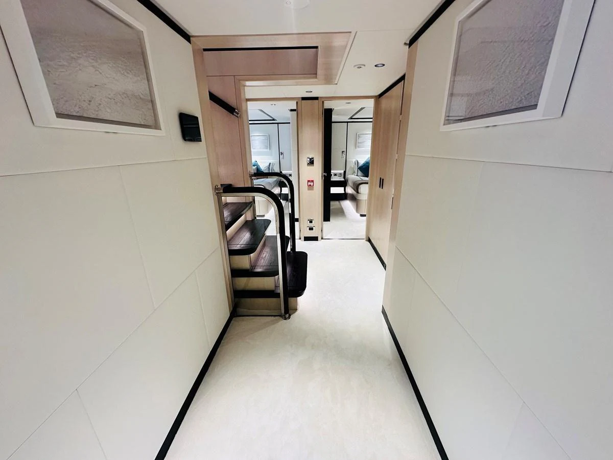 A sleek and modern hallway with stairs leading to another level of the yacht. aboard OPTIMISM Yacht for Sale