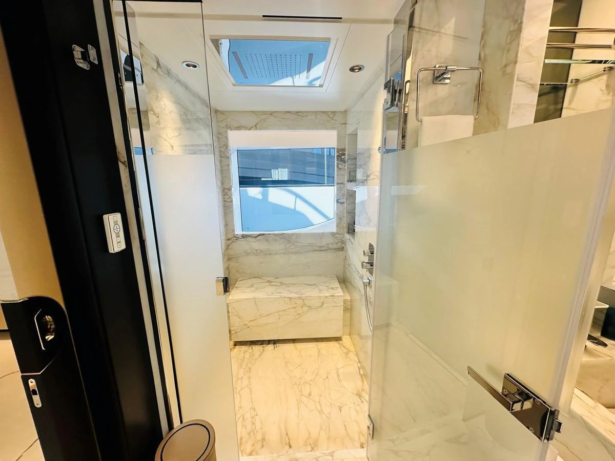 A luxurious yacht bathroom featuring marble surfaces and a spacious shower area. aboard OPTIMISM Yacht for Sale