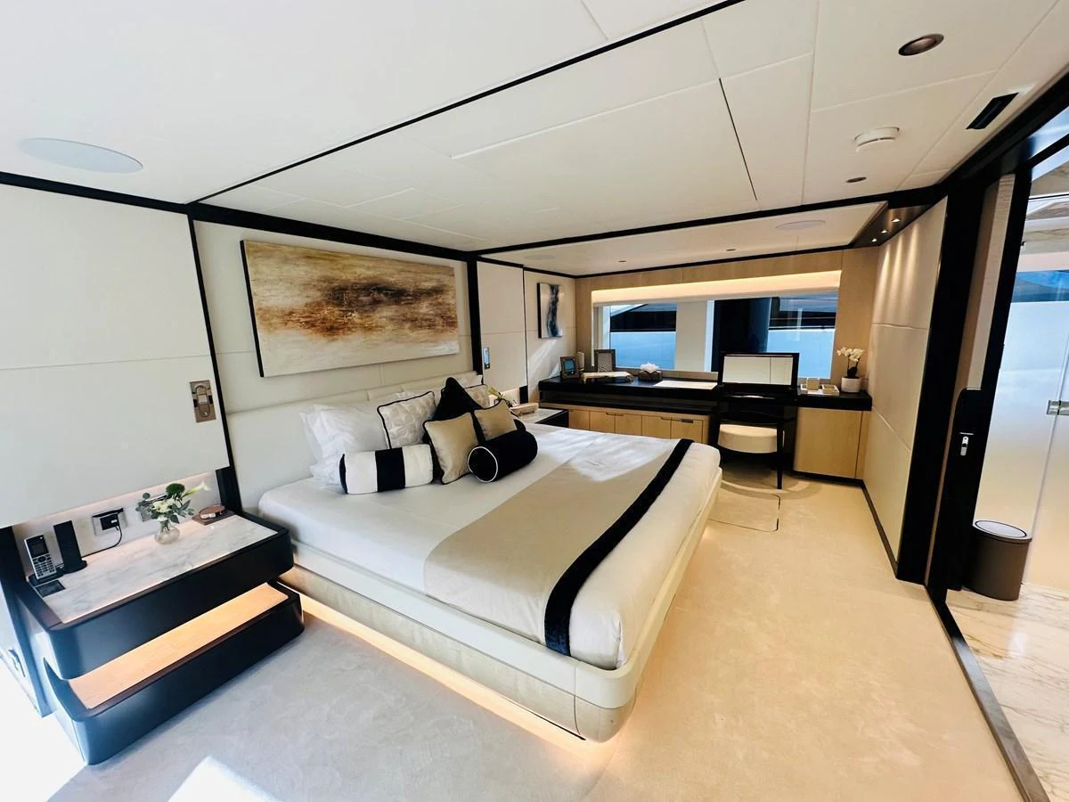 The master stateroom features a luxurious bed, elegant decor, and ample natural light. aboard OPTIMISM Yacht for Sale