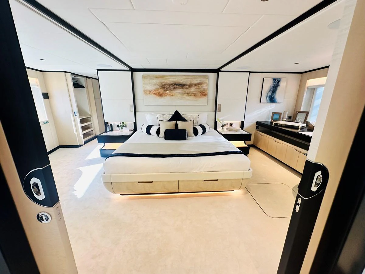 The master stateroom features a luxurious bed with elegant decor and ample natural light. aboard OPTIMISM Yacht for Sale