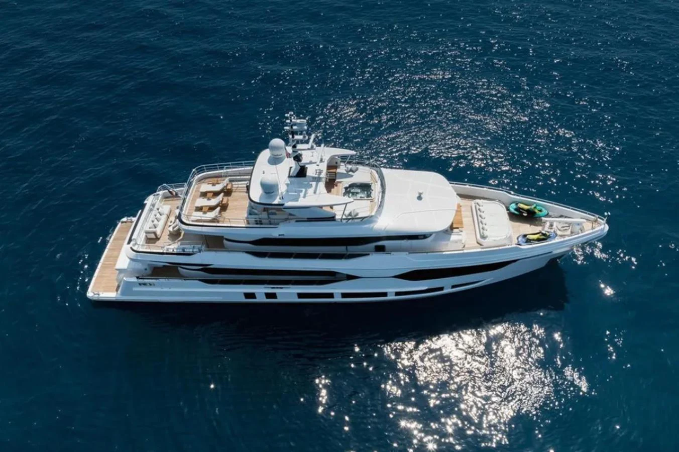 A sleek and modern yacht cruising on calm blue waters, showcasing its luxurious design and spacious decks. aboard OPTIMISM Yacht for Sale