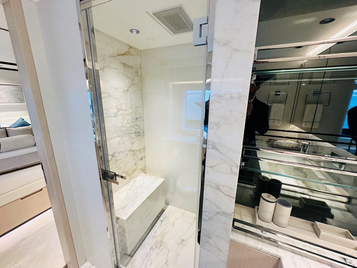 The yacht's bathroom features luxurious marble finishes and modern fixtures. aboard OPTIMISM Yacht for Sale