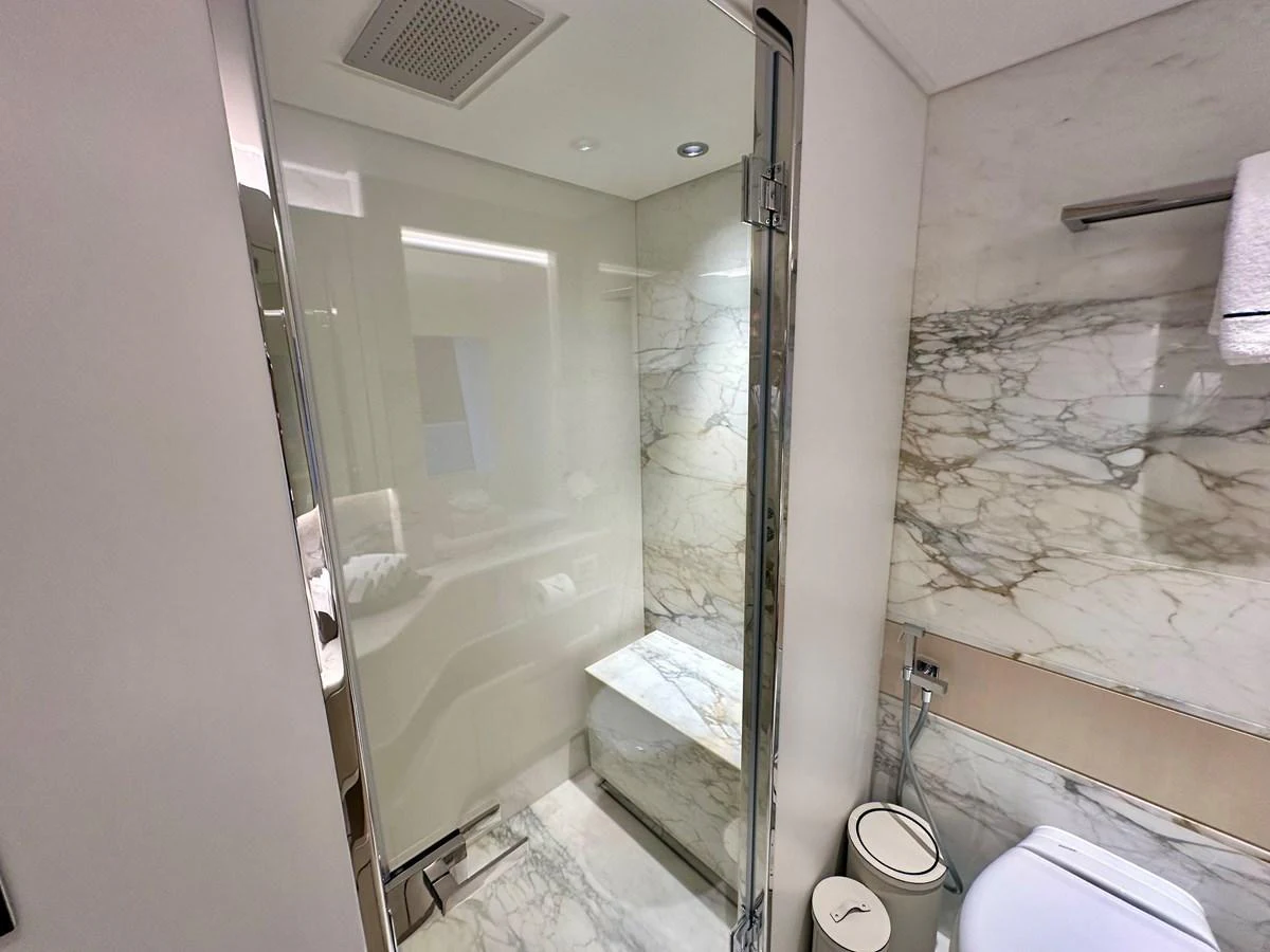 A luxurious bathroom with a glass-enclosed shower and elegant marble finishes. aboard OPTIMISM Yacht for Sale