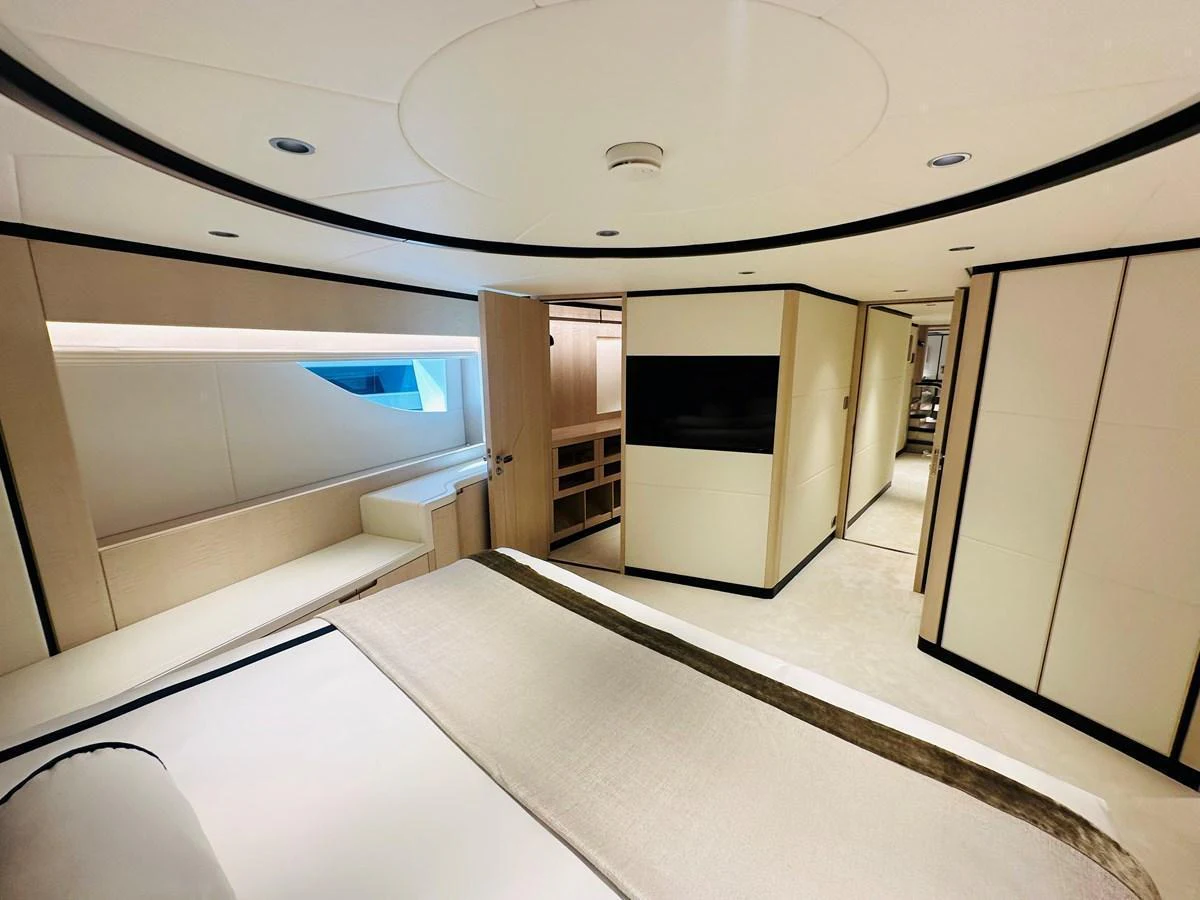 The master stateroom features a luxurious bed, modern lighting, and ample storage space. aboard OPTIMISM Yacht for Sale