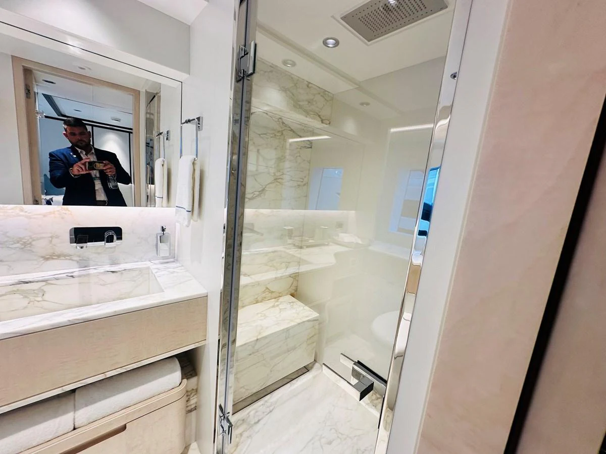 a person taking a picture of himself in a bathroom mirror aboard OPTIMISM Yacht for Sale