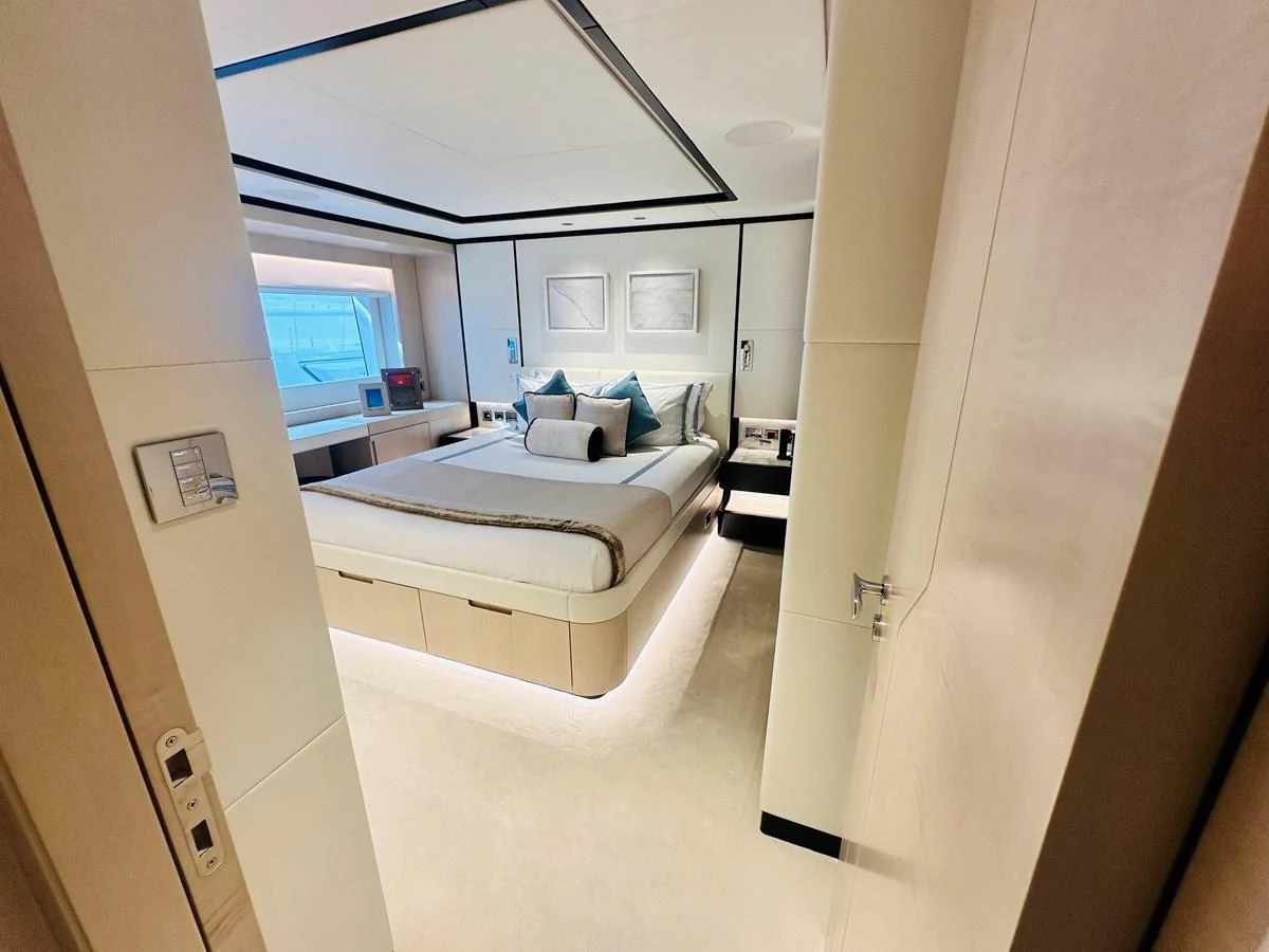 A luxurious stateroom with a large bed, elegant decor, and ample natural light. aboard OPTIMISM Yacht for Sale