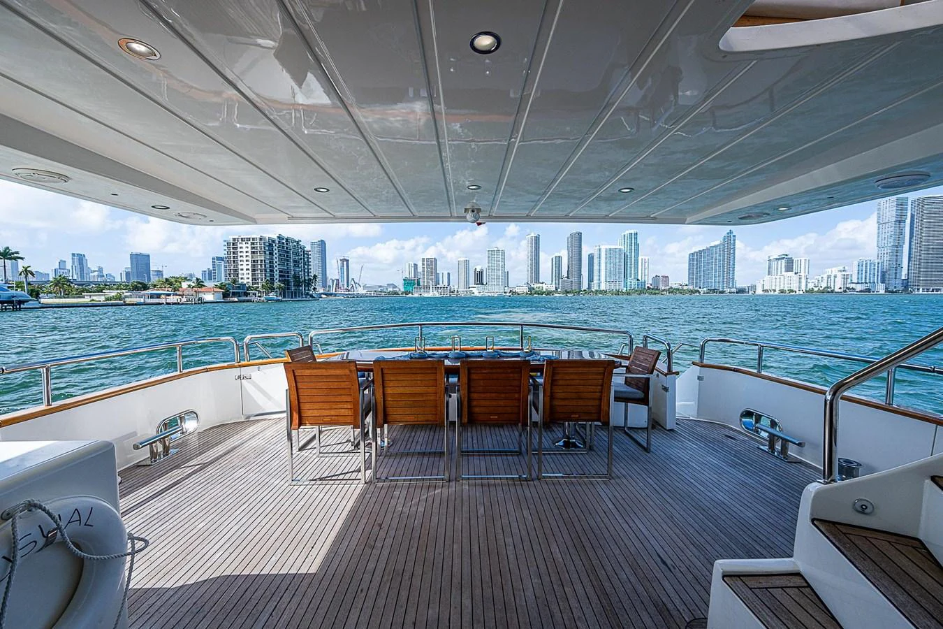 a deck with chairs and a large body of water in the background aboard THE USUAL Yacht for Sale