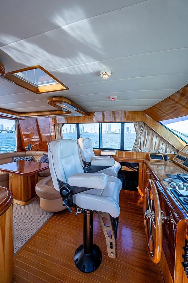 a room with a chair and a table and a large window aboard THE USUAL Yacht for Sale