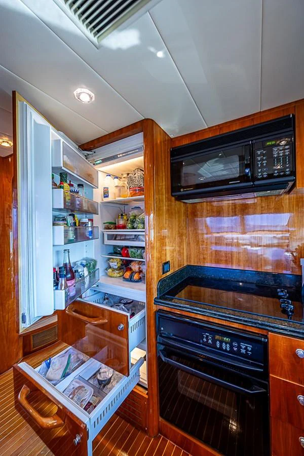 a kitchen with a microwave oven and shelves aboard THE USUAL Yacht for Sale