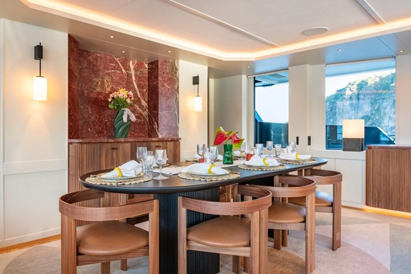 a dining table with chairs and a large window aboard COCOON Yacht for Sale