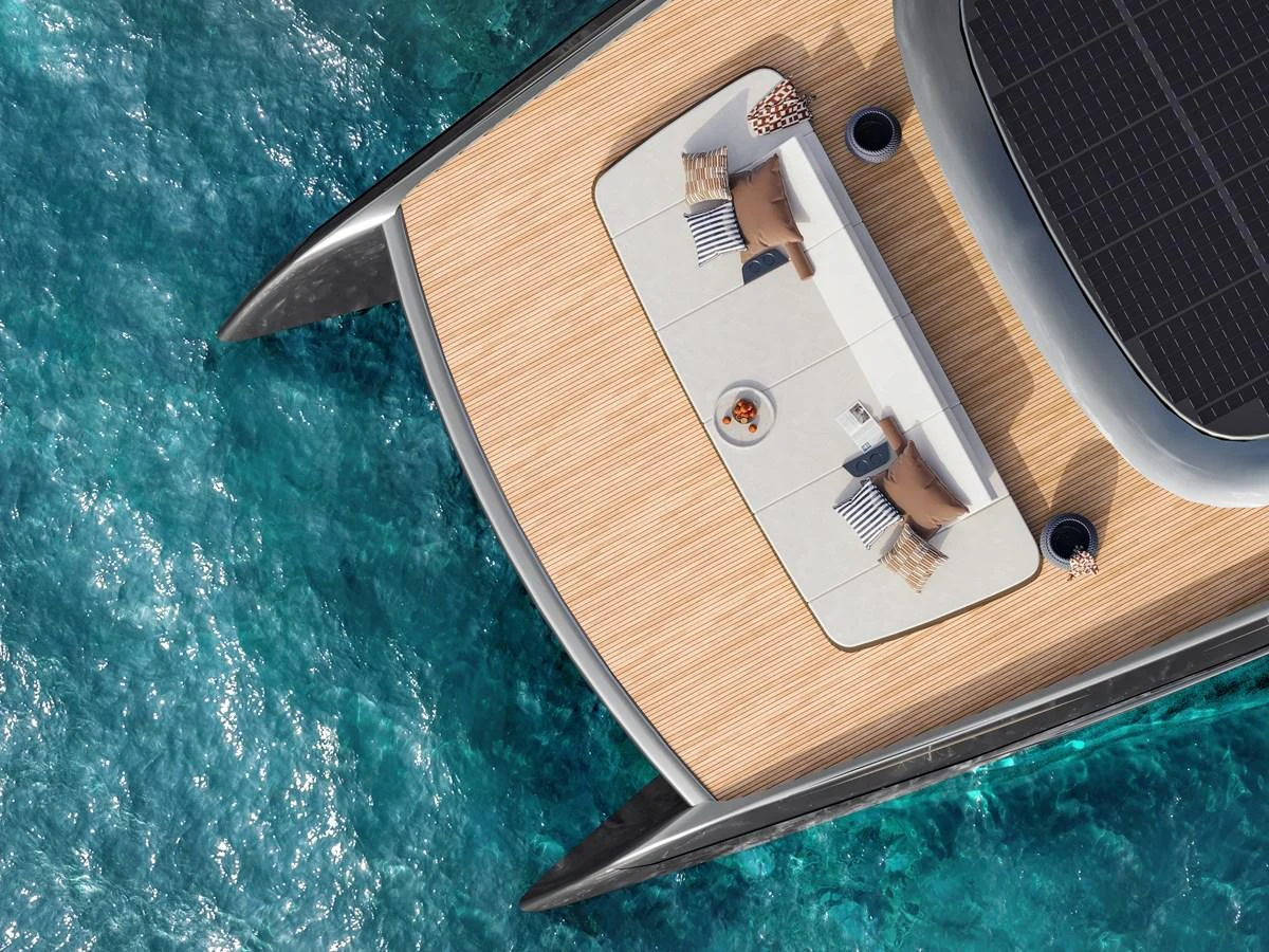 A sleek yacht deck with a modern design, featuring a spacious lounging area and surrounded by clear blue waters. aboard ULTIMA 88 Yacht for Sale