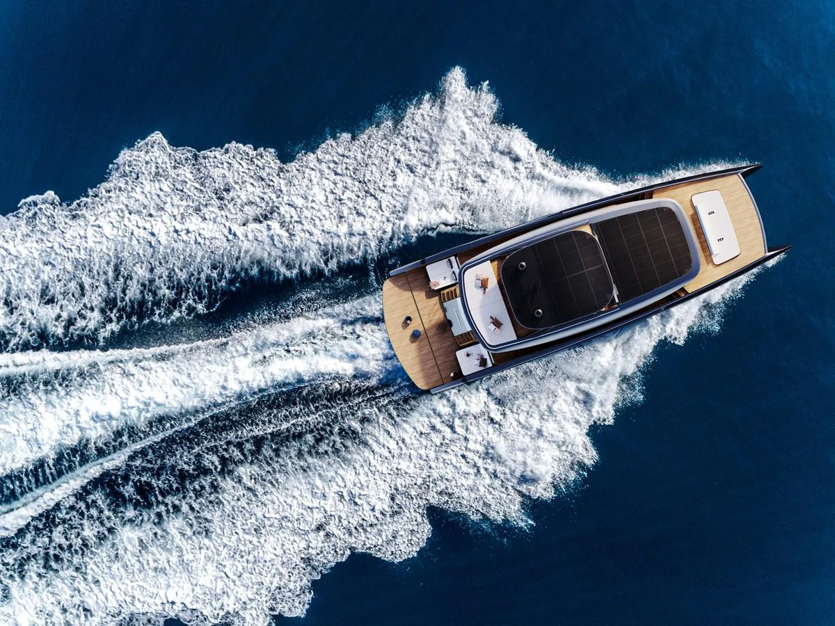 A sleek yacht cuts through the water, leaving a trail of white foam in its wake. aboard ULTIMA 88 Yacht for Sale