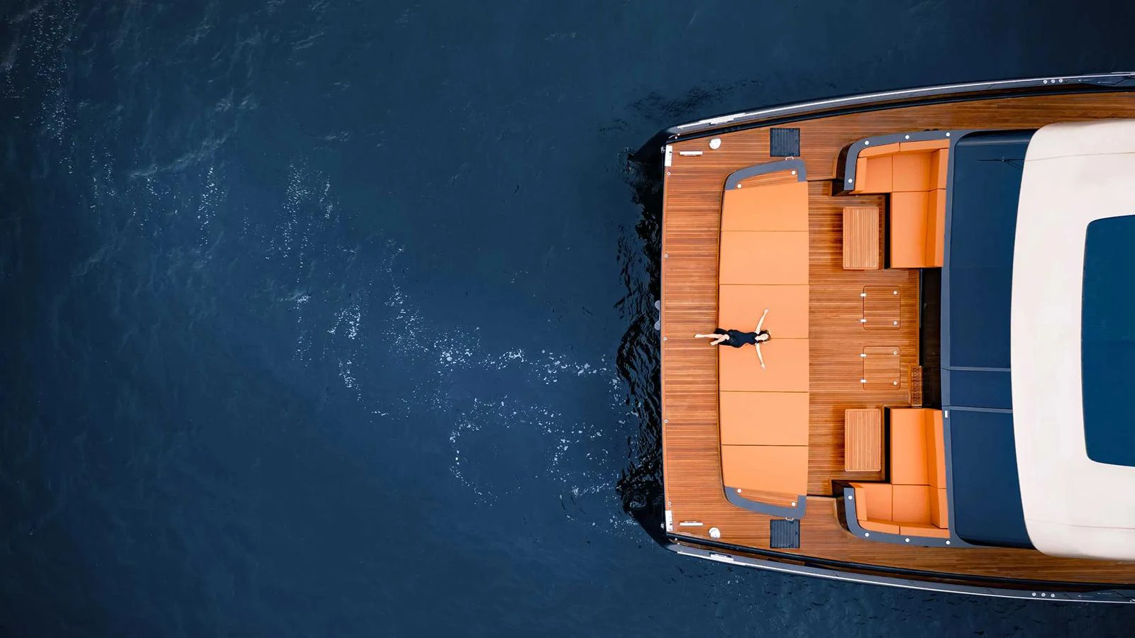 A luxurious aft deck with sun loungers and a person relaxing, captured from an aerial view. aboard 100 SUNREEF POWER NEXT Yacht for Sale