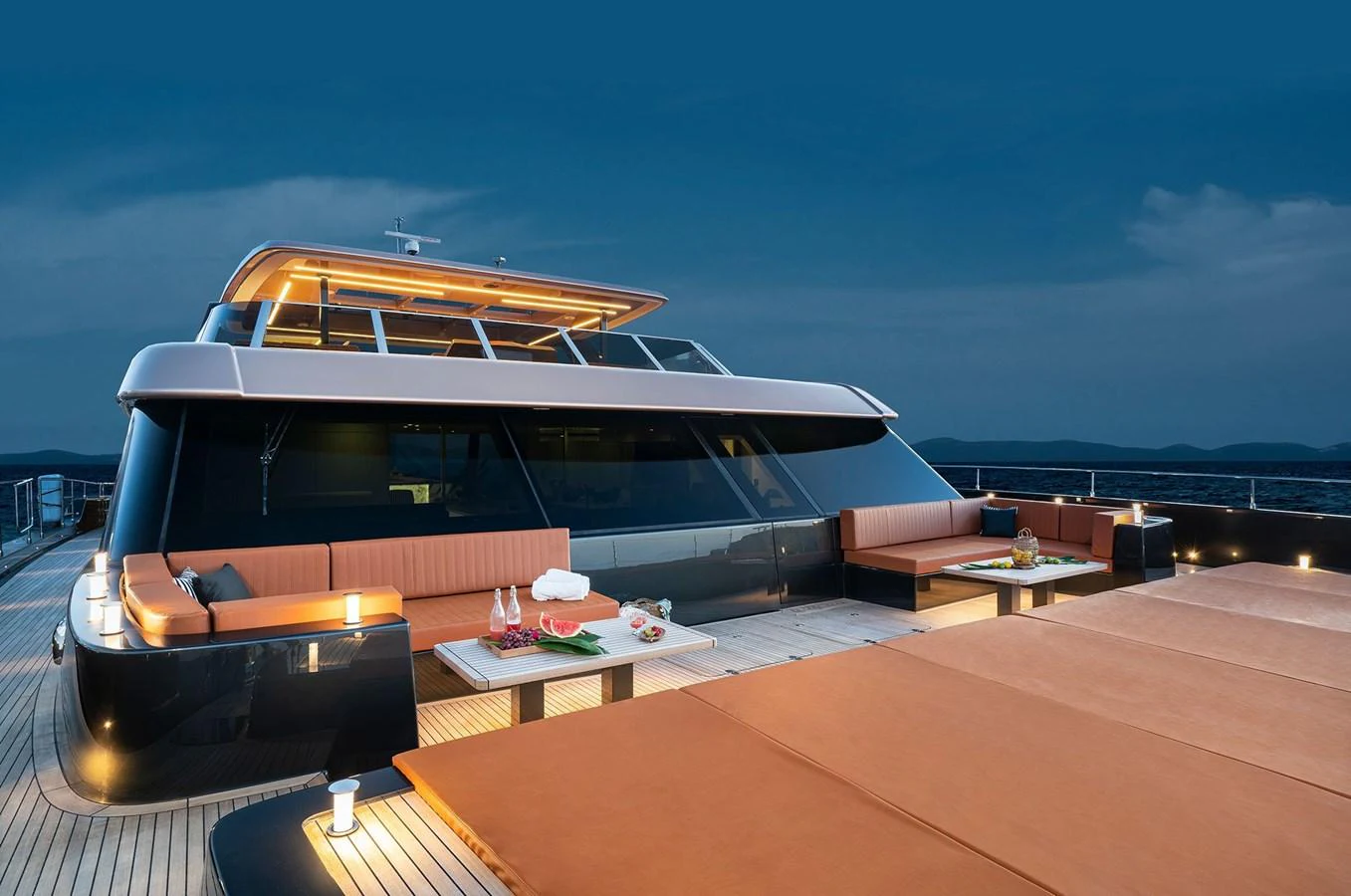 The yacht's aft deck features a luxurious lounging area with ample seating and elegant lighting, perfect for evening relaxation. aboard 100 SUNREEF POWER NEXT Yacht for Sale