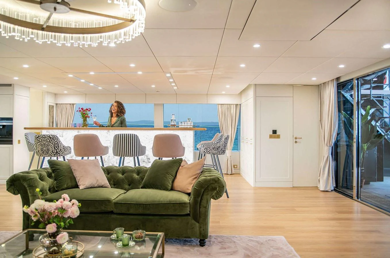 The yacht's salon features a luxurious seating area with a plush green sofa and a stylish bar counter. aboard 100 SUNREEF POWER NEXT Yacht for Sale