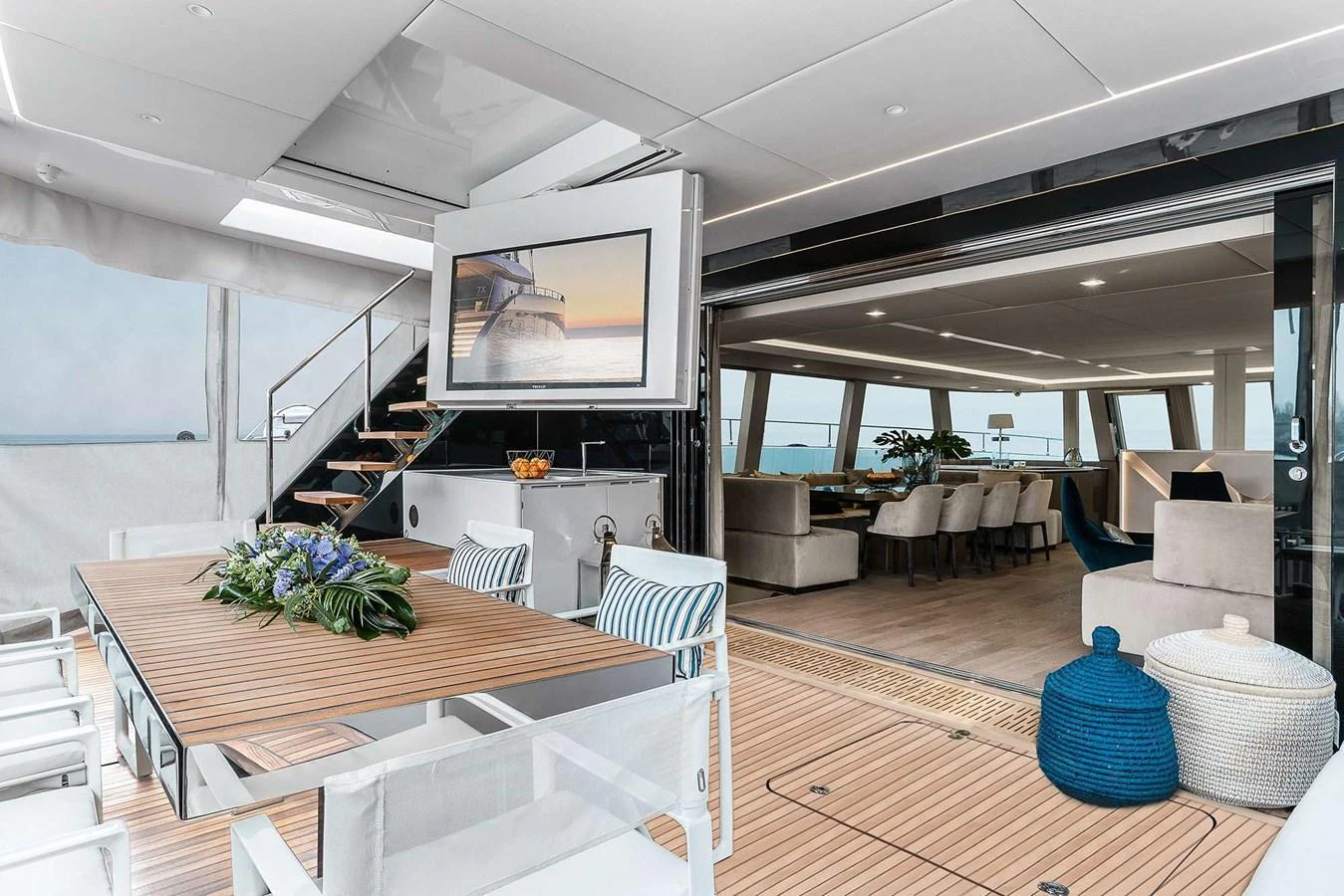 The aft deck features a stylish dining area with a view into the luxurious salon. aboard SUNREEF 80 NEXT Yacht for Sale