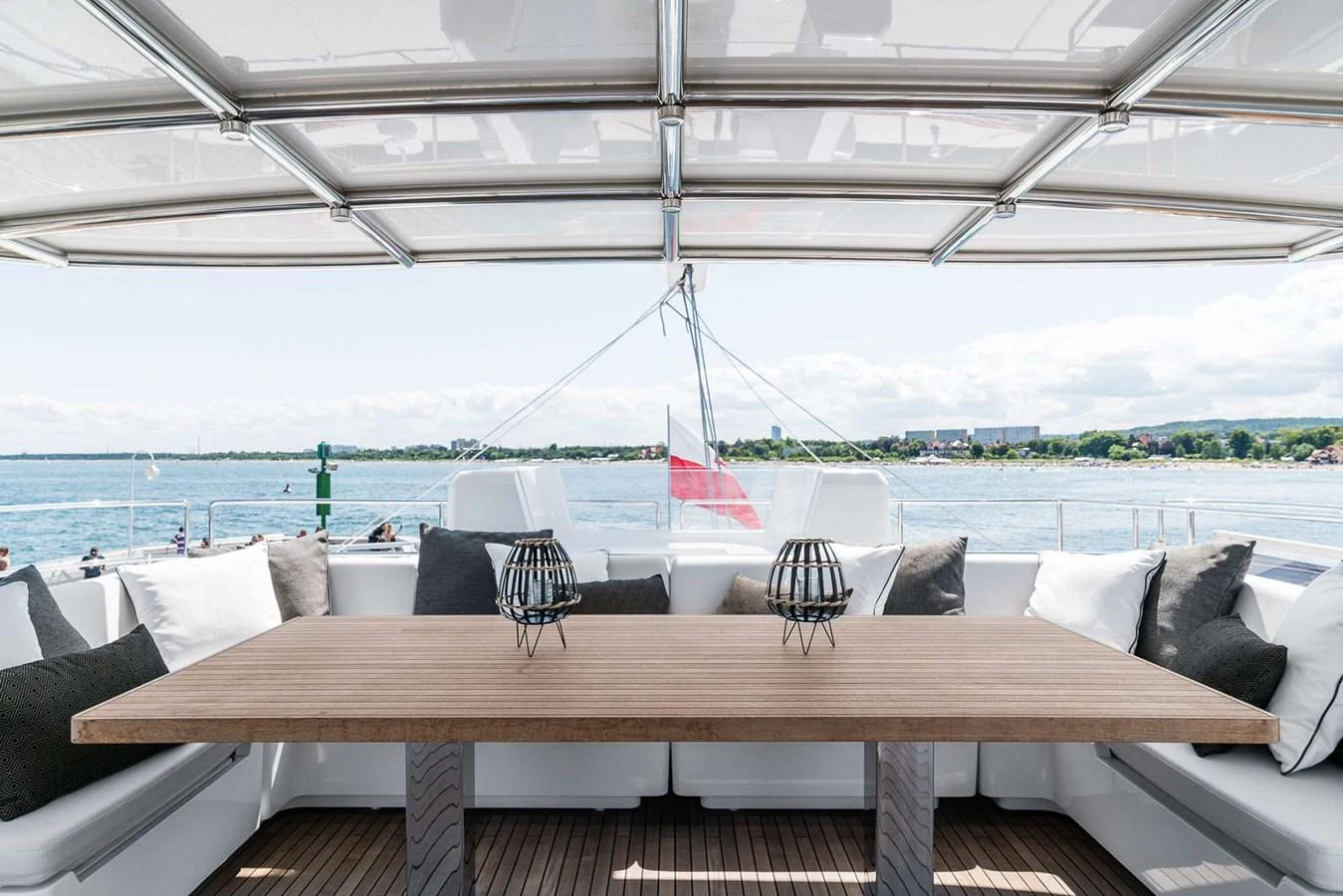 The aft deck features a spacious dining area with a large table and comfortable seating, perfect for enjoying meals with a view. aboard SUNREEF 80 NEXT Yacht for Sale
