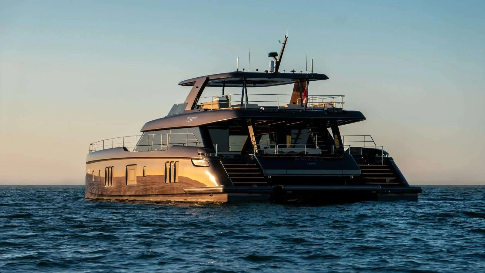 A sleek and modern yacht cruising on calm waters at sunset. aboard 70 SUNREEF POWER NEXT Yacht for Sale
