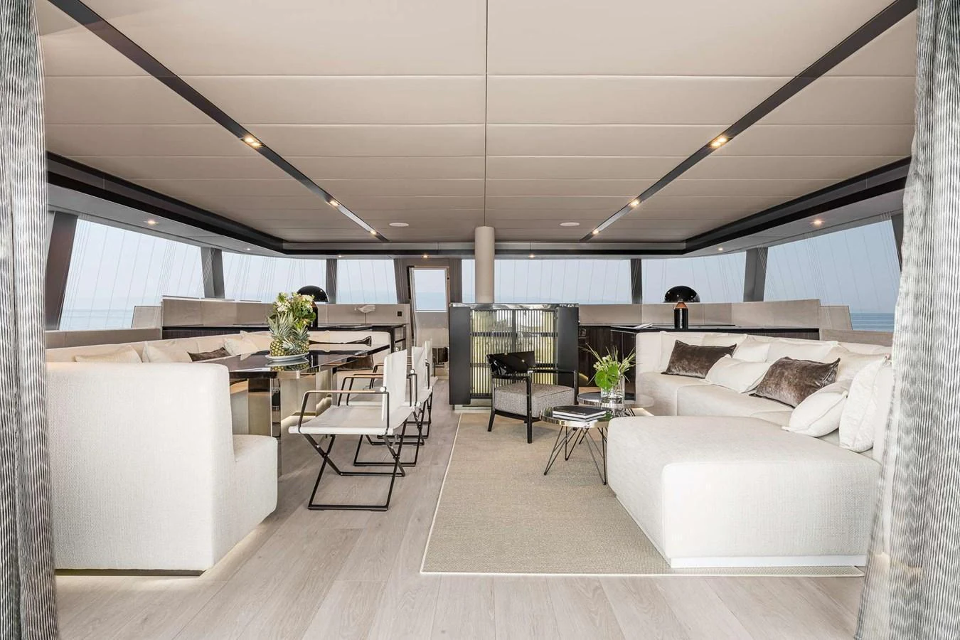 The yacht's salon features a spacious and elegantly designed seating area with modern furnishings and large windows offering panoramic views. aboard SUNREEF 70 NEXT Yacht for Sale