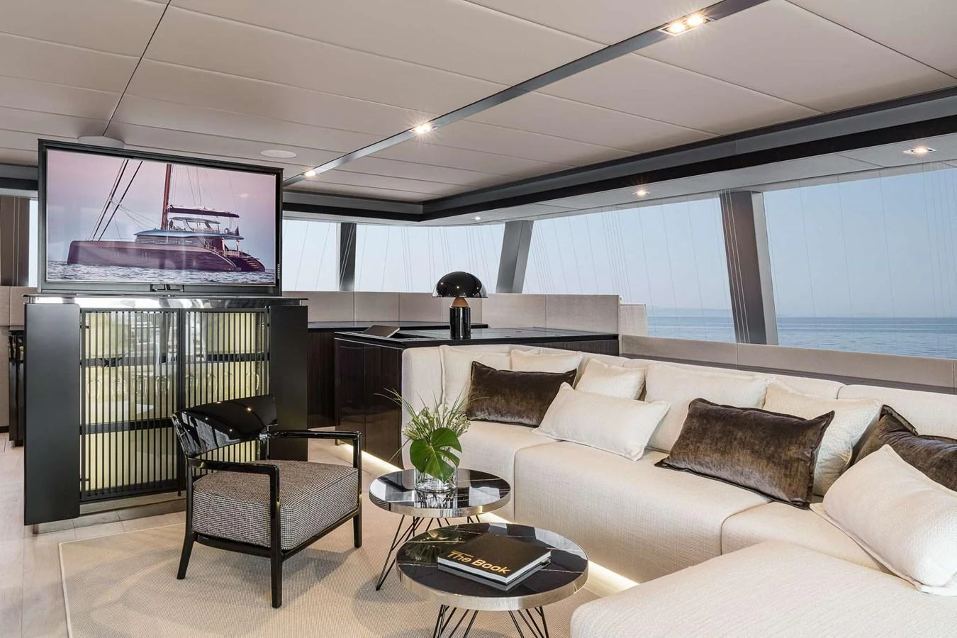 The salon features luxurious seating, a flat-screen TV, and panoramic windows offering stunning ocean views. aboard SUNREEF 70 NEXT Yacht for Sale
