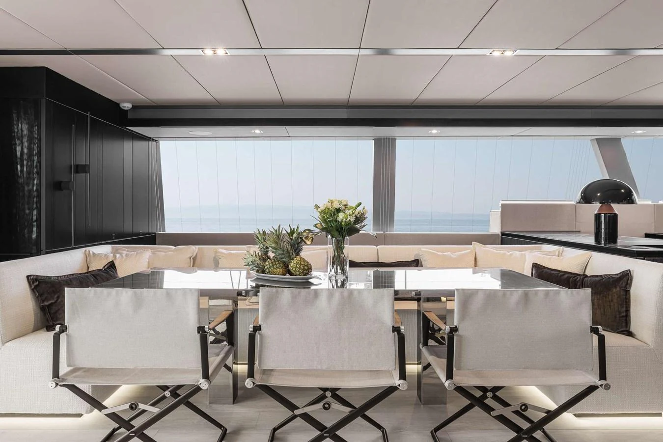 The yacht's interior dining area features a sleek and modern design with a large table and comfortable seating. aboard SUNREEF 70 NEXT Yacht for Sale