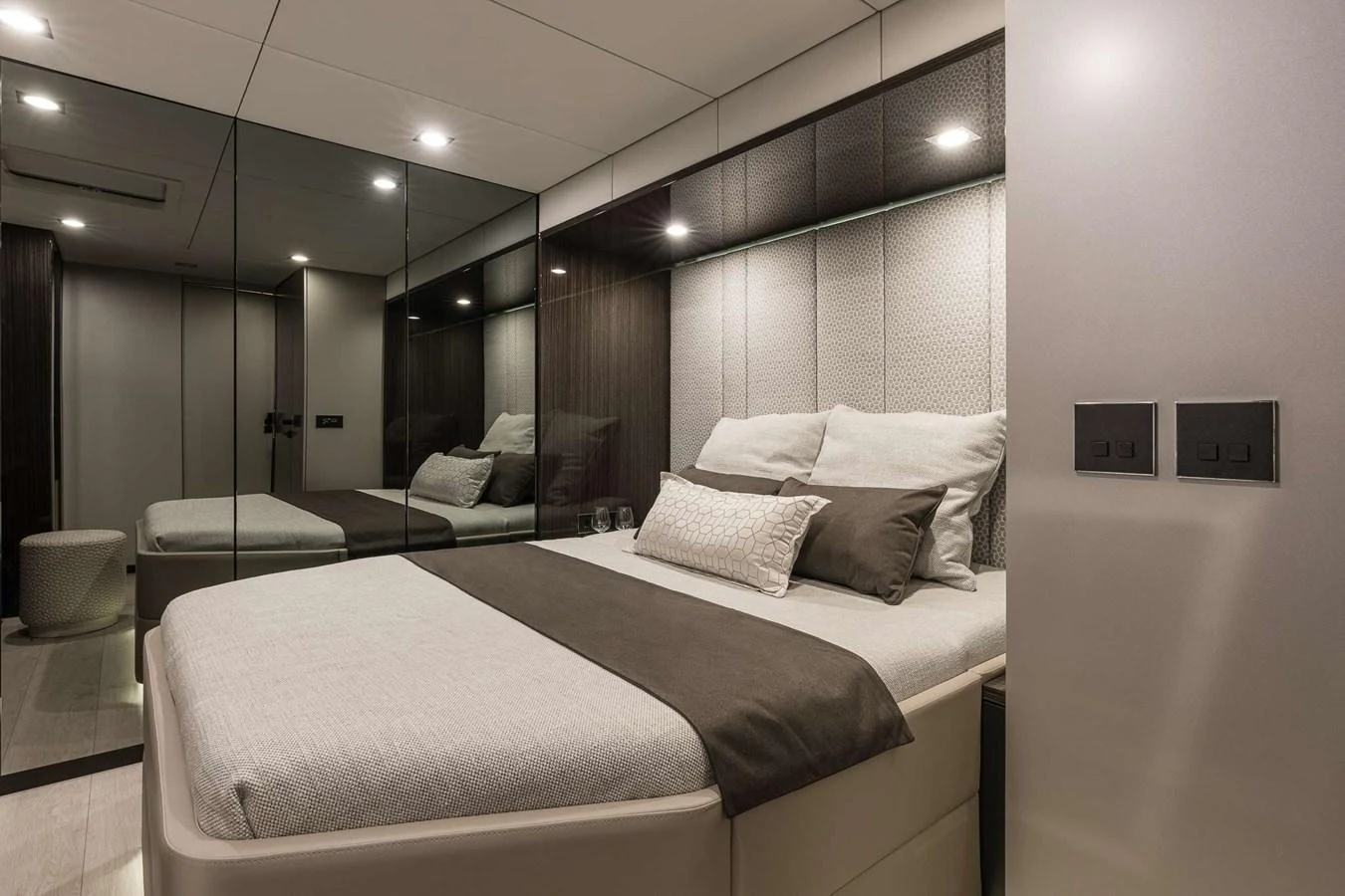 The stateroom features a plush bed with elegant bedding and mirrored walls, creating a spacious and luxurious ambiance. aboard SUNREEF 70 NEXT Yacht for Sale