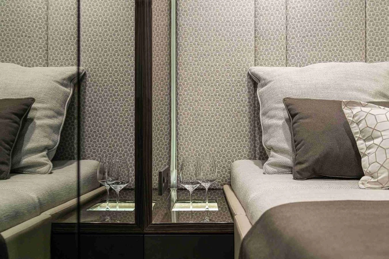 A luxurious stateroom featuring elegant bedding and a mirrored nightstand with glassware. aboard SUNREEF 70 NEXT Yacht for Sale